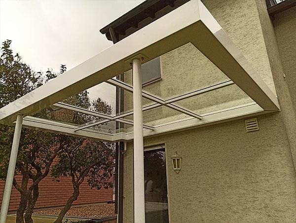 Ein weißes Haus mit einem Glasdach über der Tür