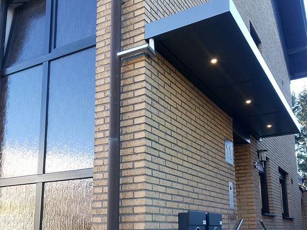 Ein Backsteingebäude mit einem Vordach über der Eingangstür