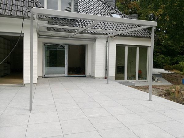 Ein weißes Haus mit einer überdachten Terrasse davor