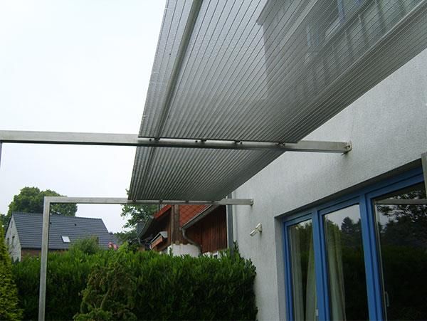 Ein weißes Gebäude mit einem blauen Fenster und einem Baldachin darüber