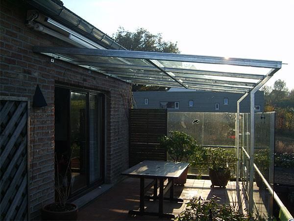 Ein Balkon mit Glasdach und Tisch