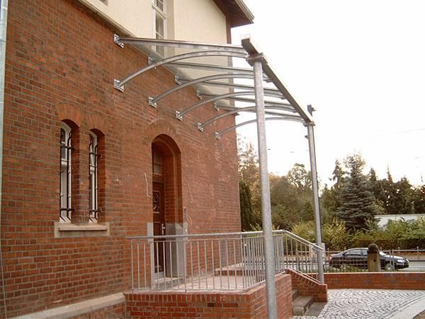 Ein Backsteingebäude mit einem Vordach über dem Eingang