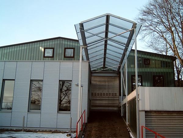 Ein Gebäude mit einem durchsichtigen Dach und einer Rampe, die dorthin führt