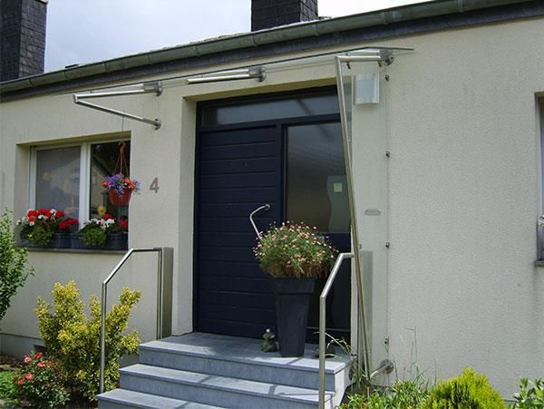 Ein weißes Haus mit einer blauen Tür und Treppe