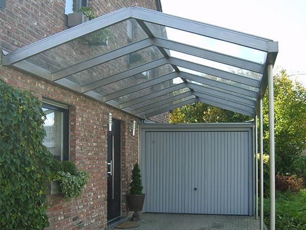 Ein Backsteinhaus mit einer Garage unter einem Vordach.