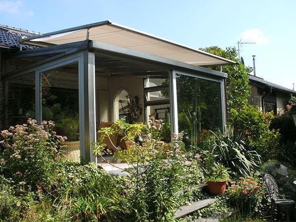 Ein Haus mit einer überdachten Veranda, umgeben von Pflanzen