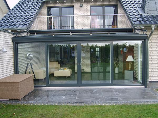 Ein Haus mit Glasschiebetüren und einem Balkon