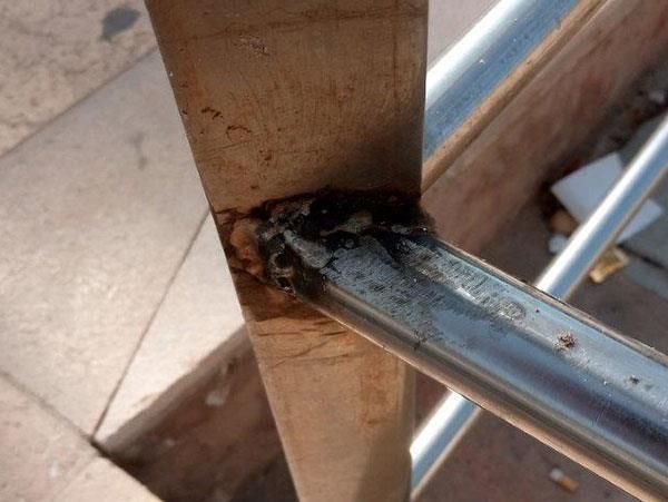 Ein Metallrohr ist an einem Holzpfosten befestigt