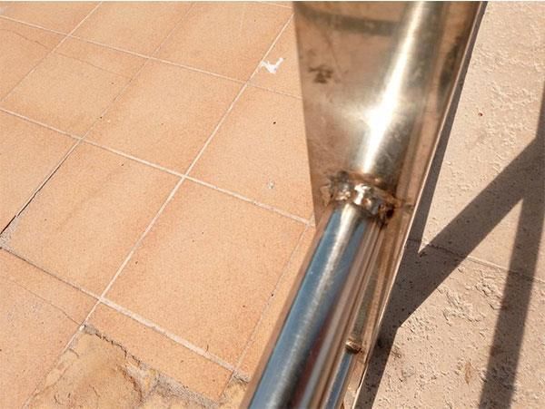 Ein Edelstahlgeländer liegt auf einem gefliesten Boden