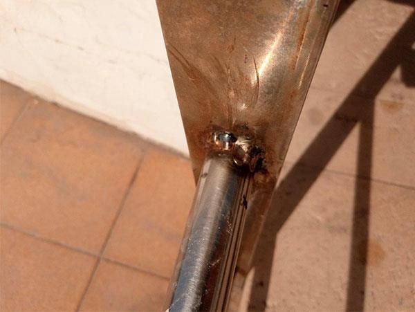 Eine Nahaufnahme eines Metallrohrs auf einem gefliesten Boden