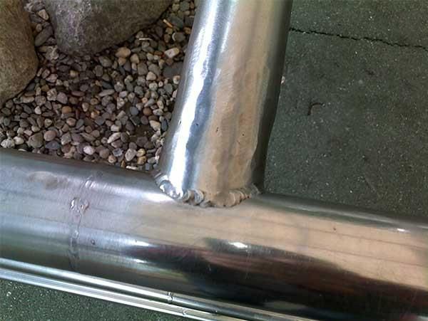 Ein Metallrohr liegt auf einem Kieshaufen.