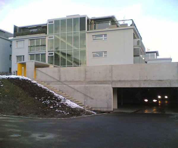 ein großes weißes Gebäude mit vielen Fenstern und einem Tunnel darunter