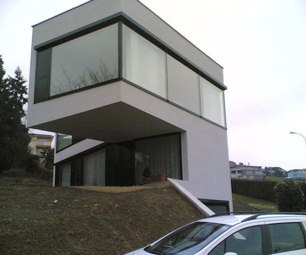 ein weißes Auto steht vor einem weißen Gebäude mit vielen Fenstern