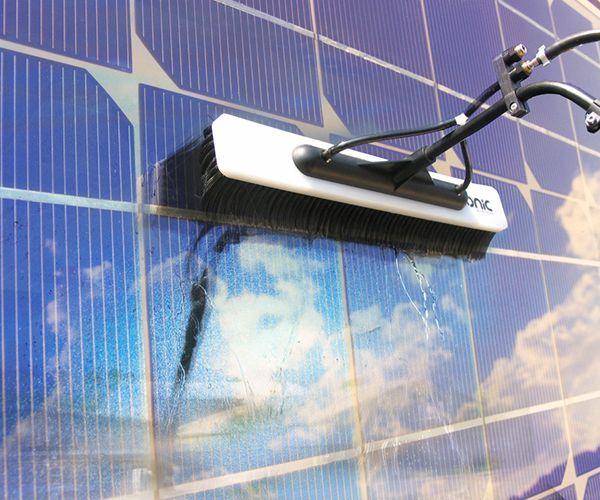 eine Bürste reinigt ein Solarpanel