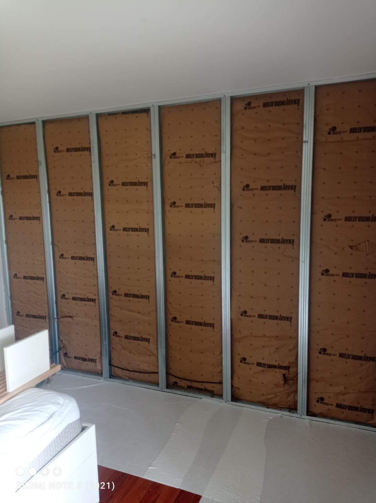 Mur intérieur en construction avec ossature métallique et isolation.