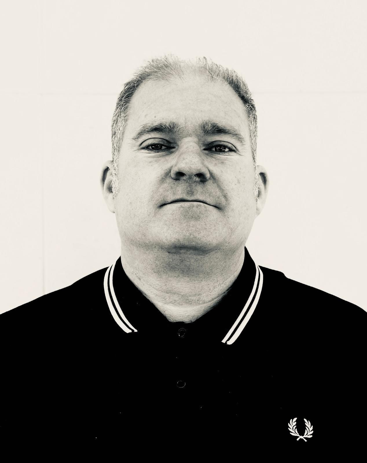 Mujer con blazer azul, trenza oscura, de espaldas a la cámara, fondo de cielo azul.