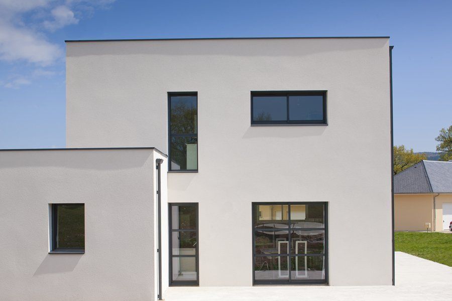 Photo d'une façade maison avec une porte vitrée, une baie coulissante et deux surfaces vitrées à l'étage