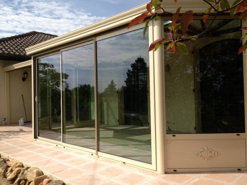 Photo d'une véranda avec de grandes baies coulissantes sur toute la longueur