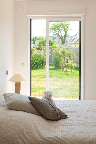 Photo d'une porte-fenêtre blanche dans une chambre.