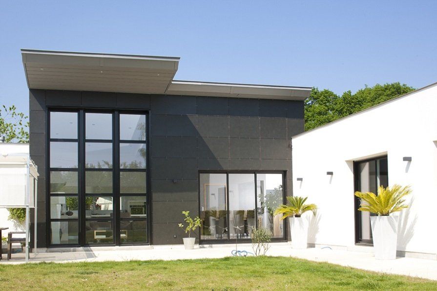 Photo de la façade d'une maison avec de grandes surfaces vitrées