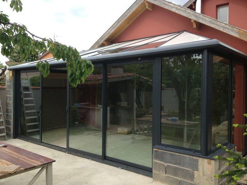 Photo d'une véranda avec baies coulissantes noires