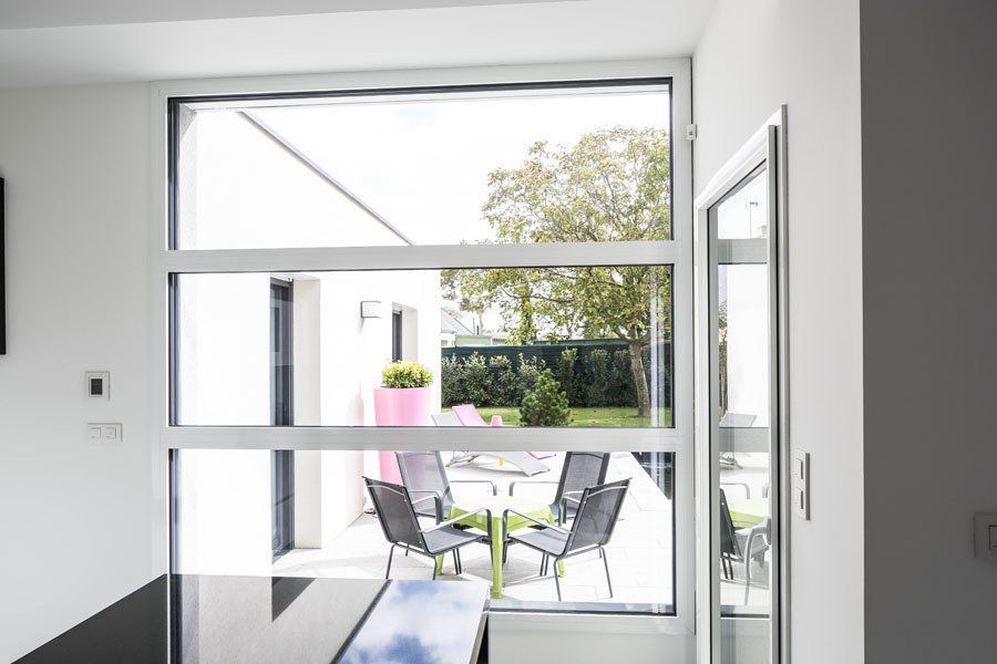 Photo d'une grande fenêtre blanche avec 3 vitres horizontales.