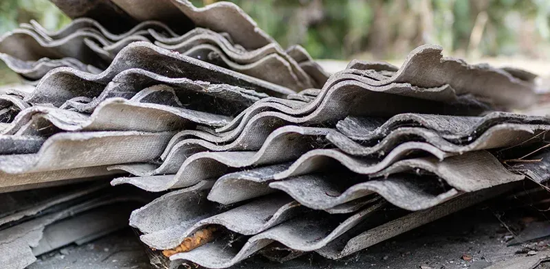 Ein Stapel grauer, gewellter Dachziegel.