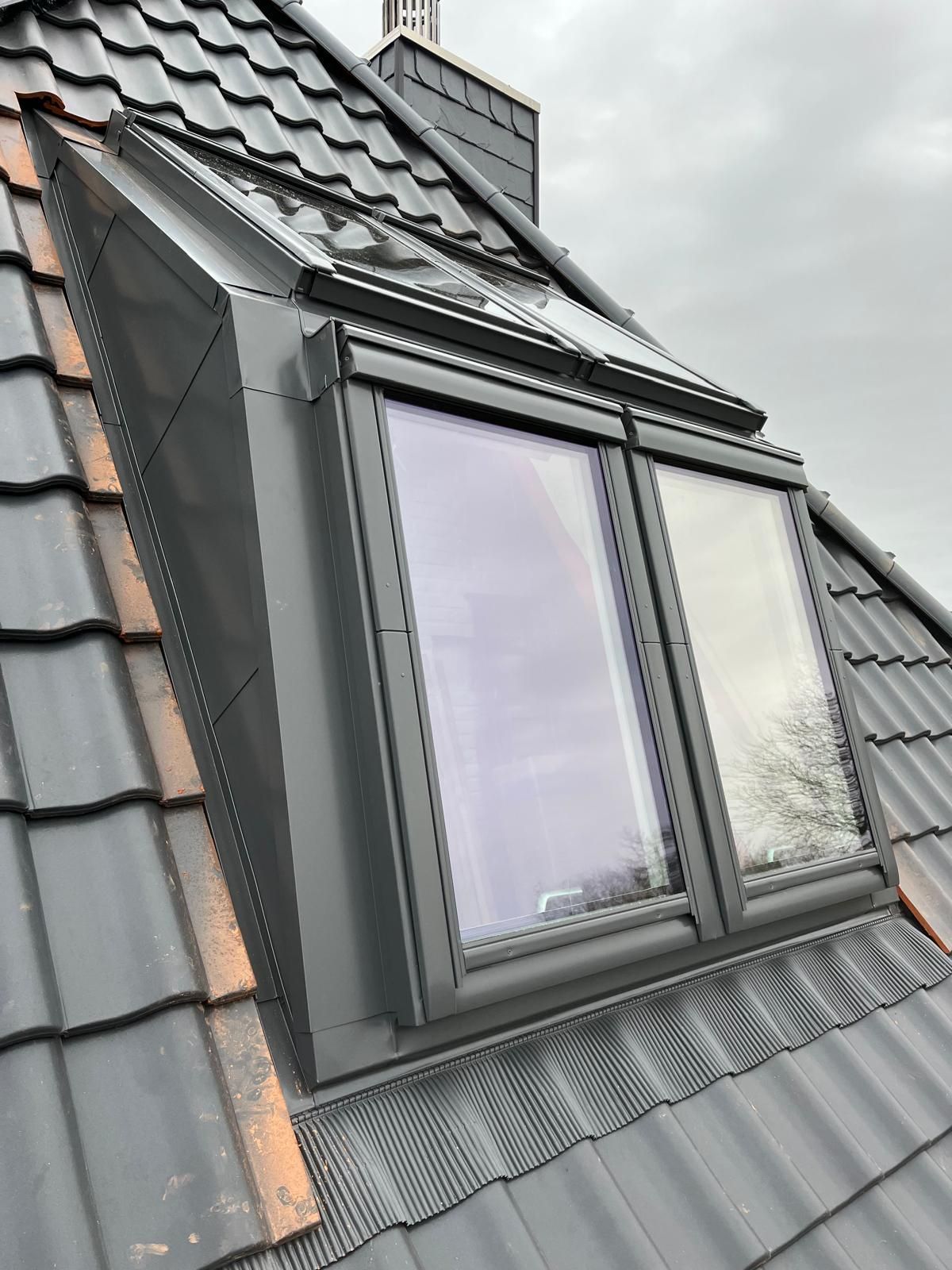 Offenes Oberlicht in einem weißen Raum mit Blick ins Grüne und auf den Himmel durch das Glas.