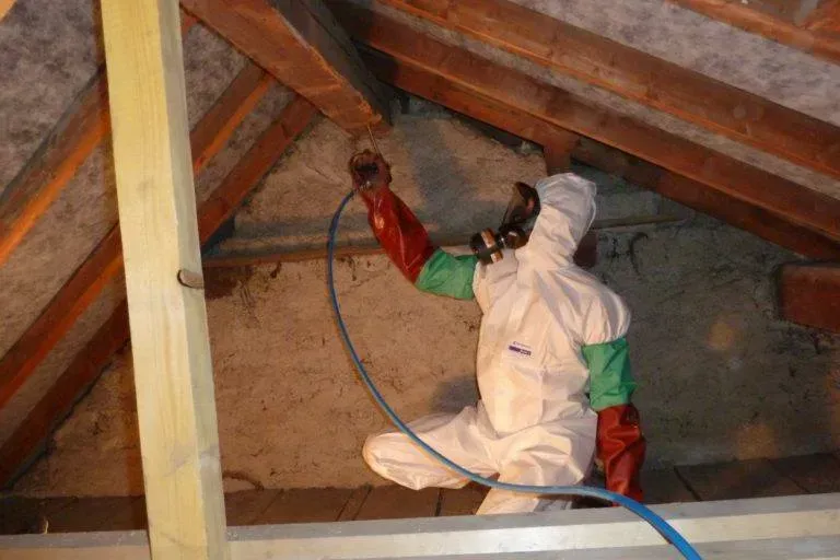 Un homme qui inject un produit dans une poutre