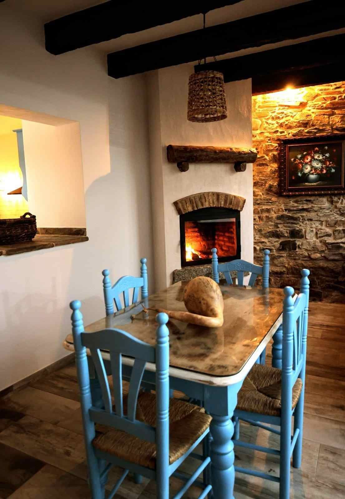 Estante blanco con toallas azules dobladas, decoración otoñal y una cesta de mimbre con flores.