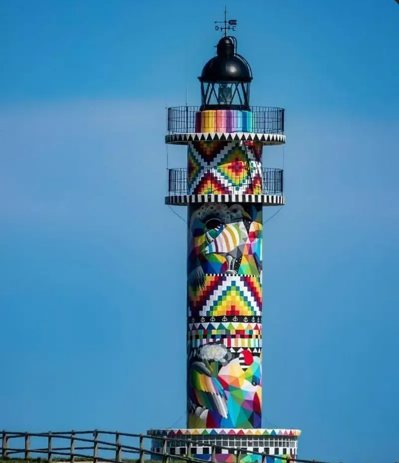 Faro pintado de vivos colores contra un cielo azul despejado