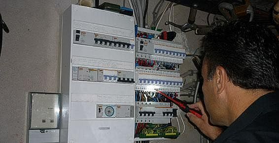 M. Lattugoni contrôle la conformité électrique d'un disjoncteur dans une habitation