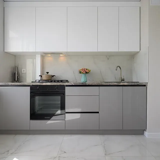Cocina moderna con gabinetes superiores blancos, gabinetes inferiores grises y salpicadero de mármol.