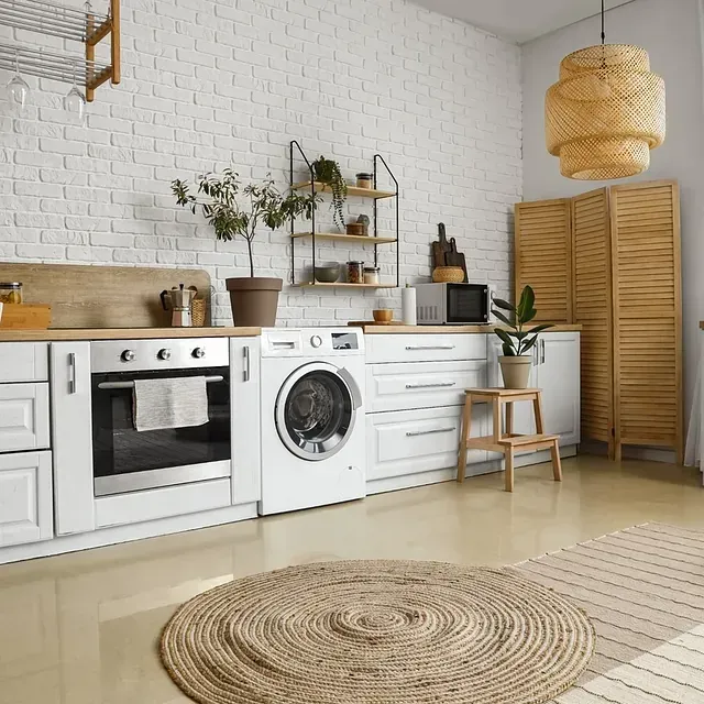 Cocina blanca con lavadora, horno, alfombra y decoración.