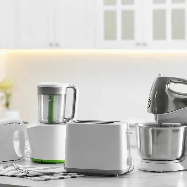 Encimera de cocina con diversos electrodomésticos en color blanco: batidora, tostadora, batidora y hervidor de agua.