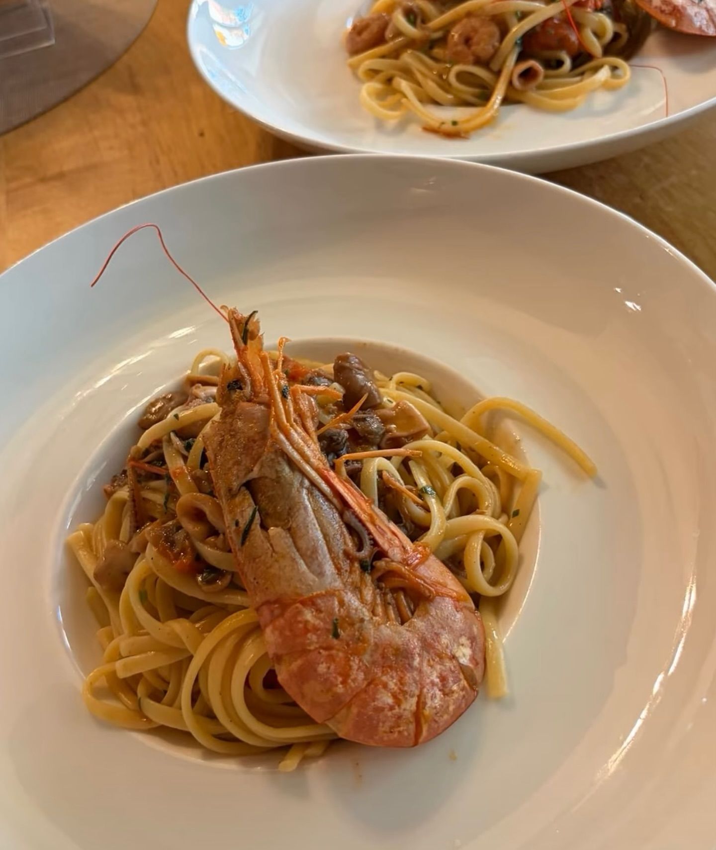 Pastagericht mit großen Garnelen, serviert in einer weißen Schüssel.