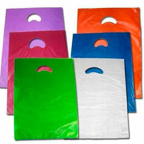 Bolsas de compras de plástico de colores con asas troqueladas, apiladas entre sí.