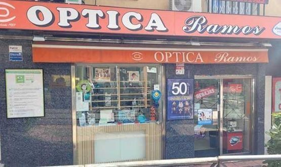 Un escaparate con un cartel que dice 'Optica Ramos'.