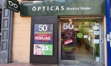 Un escaparate con un cartel que dice Óptica Madrid Visión.