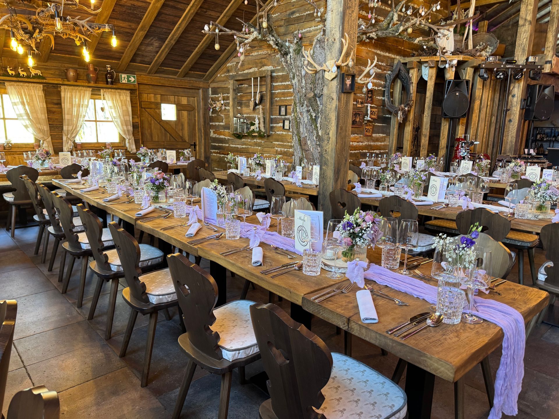 Festlich gedeckter Tisch in rustikaler Hütte für Feier oder Hochzeit