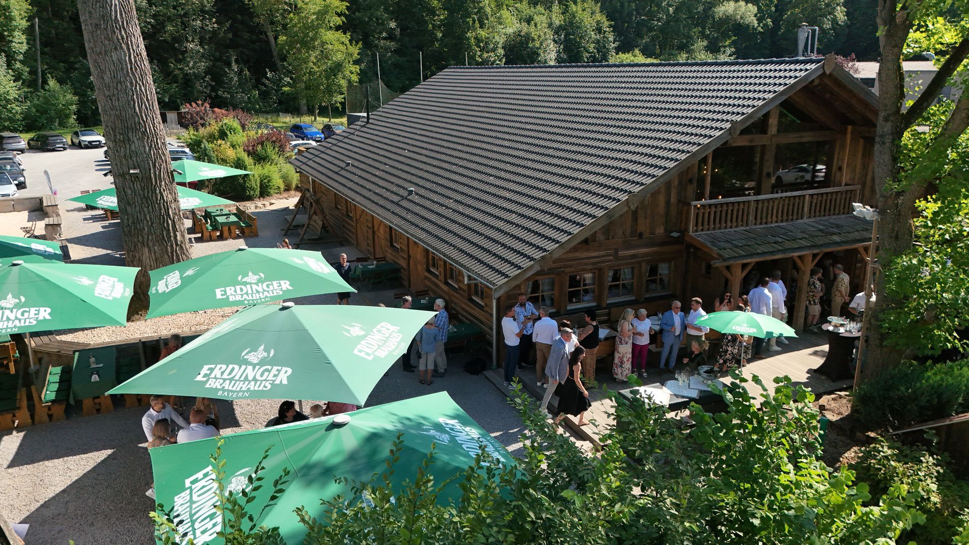 Drohnenaufnahme einer Eventlocation mit Holzhütte und Garten