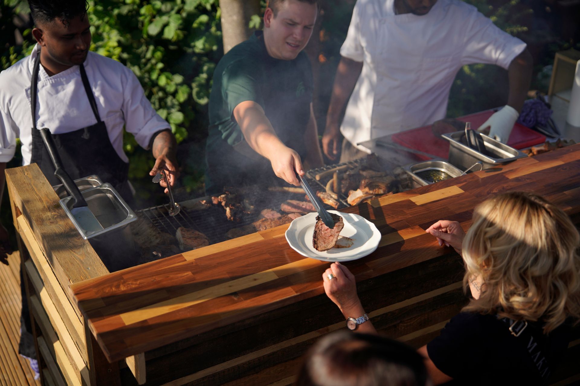 Grenz Alm - Servicepersonal legt frisch gegrilltes Fleisch auf Teller von Gast