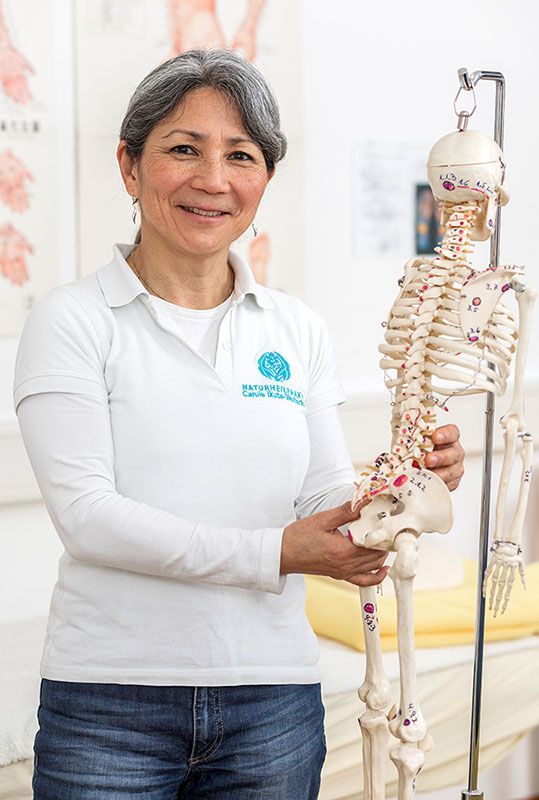 Eine Frau hält ein Skelettmodell in ihren Händen.