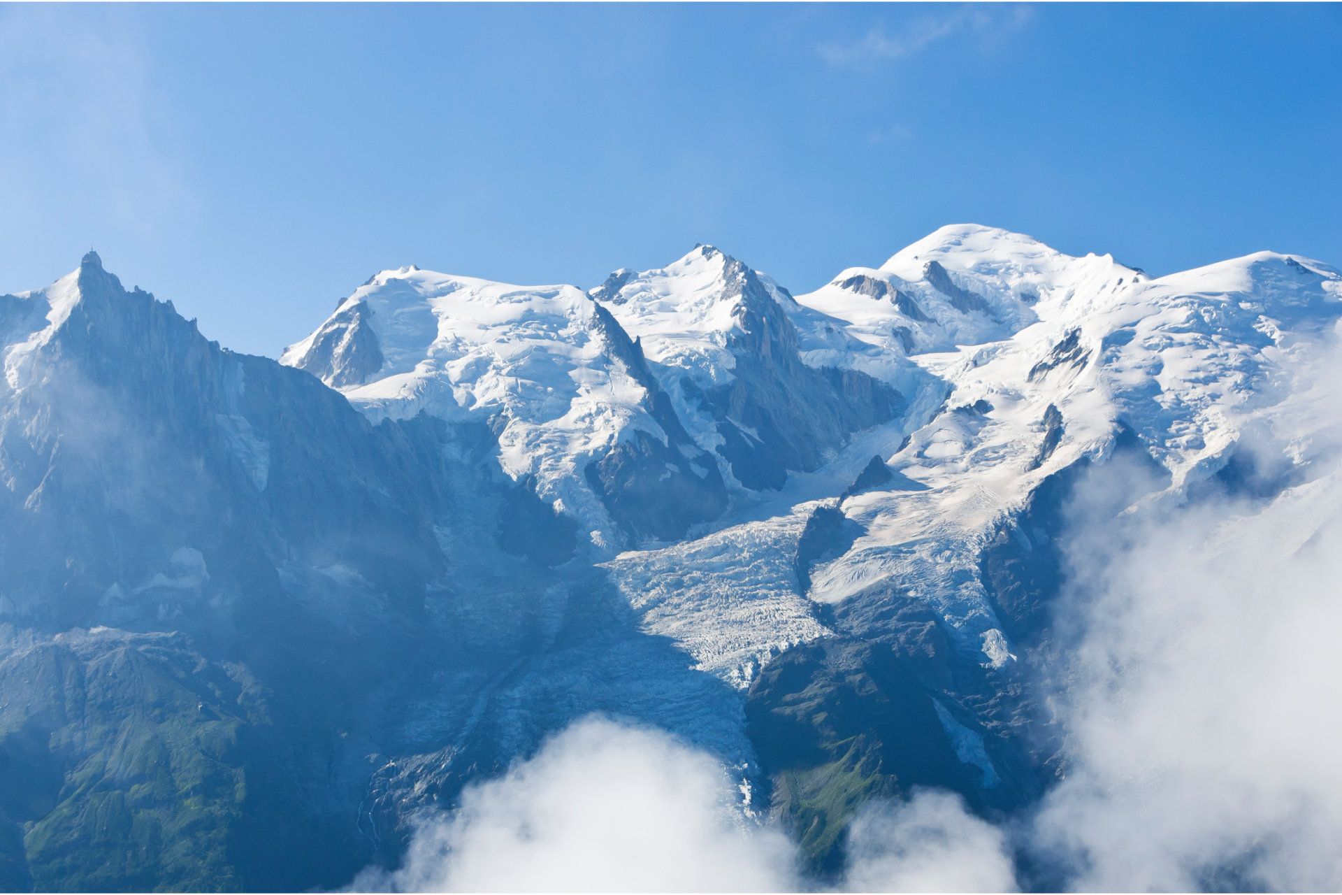 Schneebedeckte Berge mit Wolken und blauem Himmel im Hintergrund