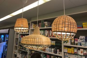 Tres lámparas de mimbre cuelgan del techo de una tienda.