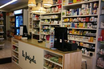 Una farmacia con muchos estantes y un mostrador.