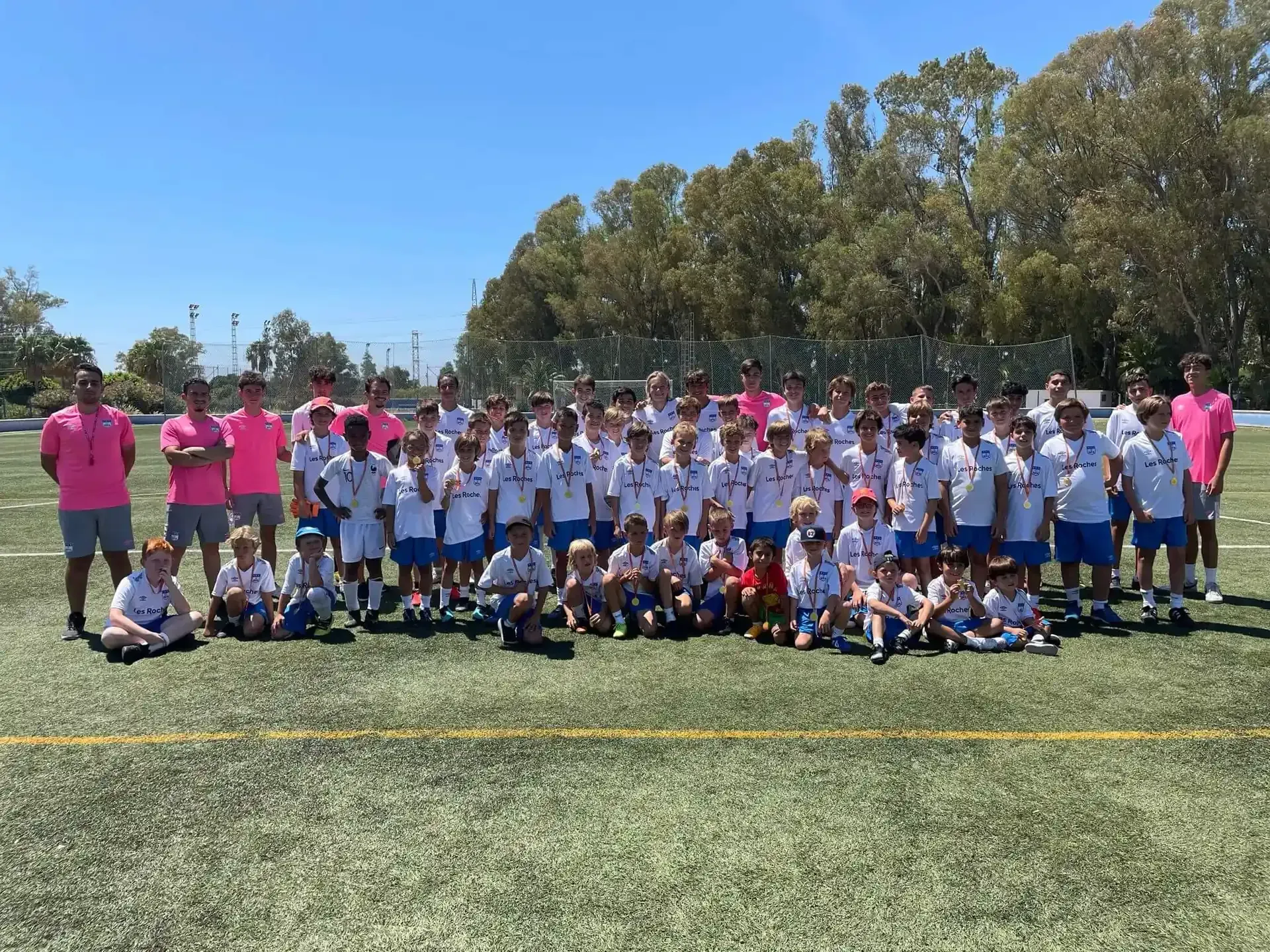 Un grupo de niños posa para una foto en un campo de fútbol.