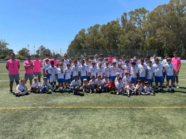 Un grupo de niños posa para una foto en un campo de fútbol.