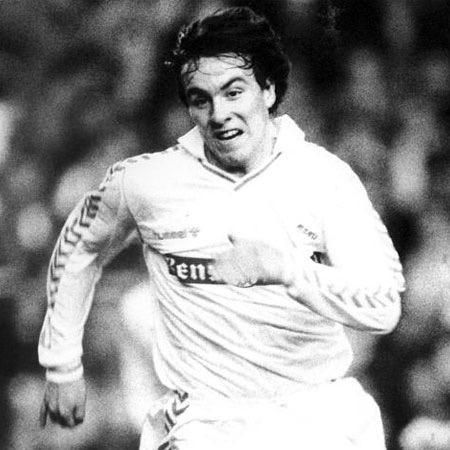 Una fotografía en blanco y negro de un jugador de fútbol corriendo en el campo.