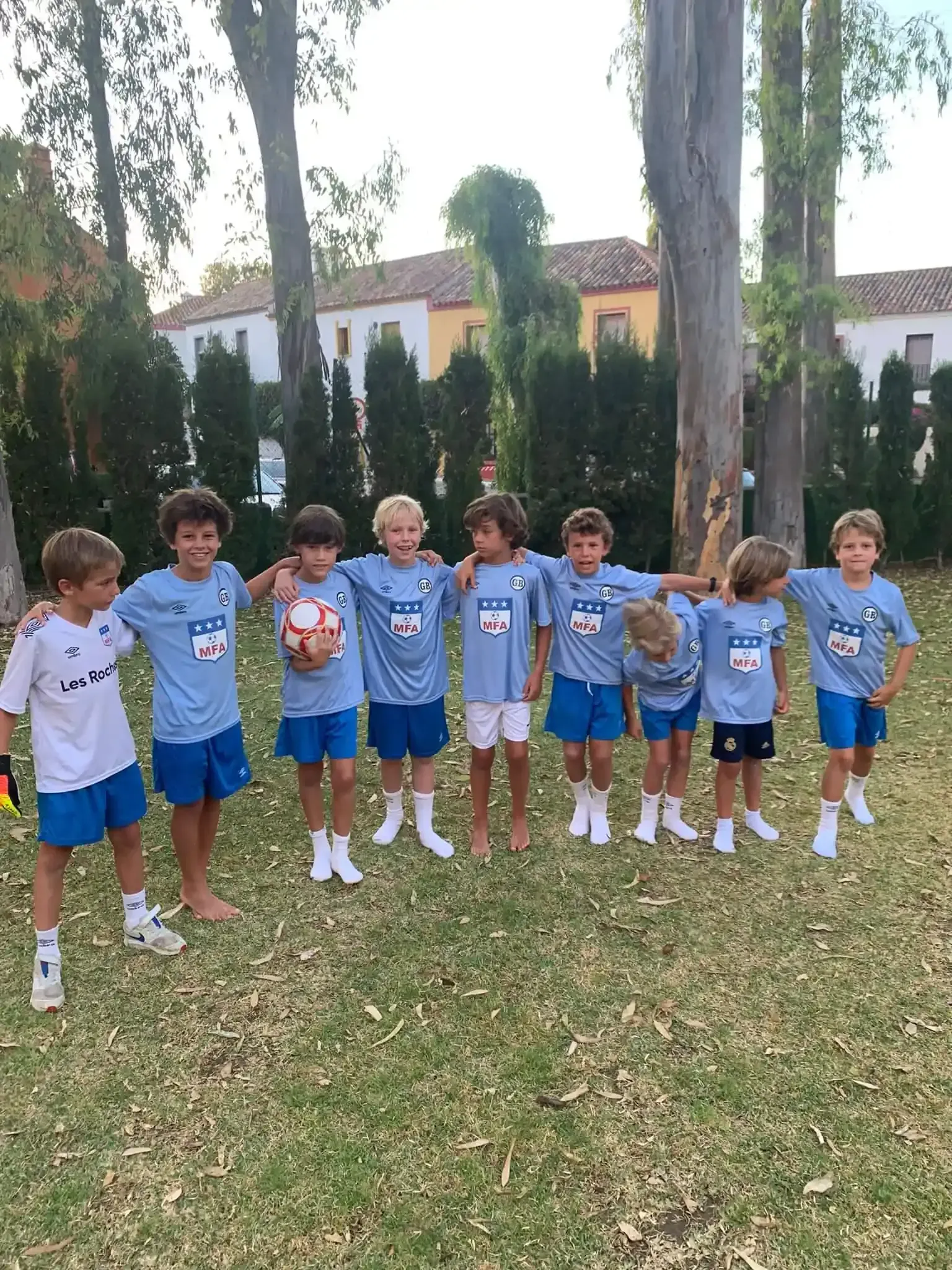 Un grupo de niños están parados uno al lado del otro en un campo.